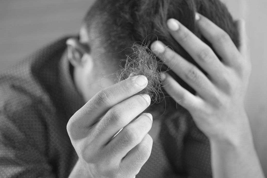 A man running his hands through his short hair
