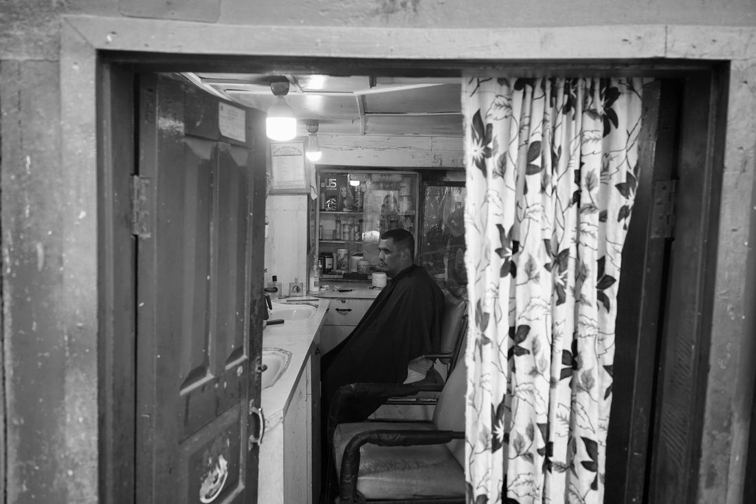 The open doorway of a small old-fashioned barbershop