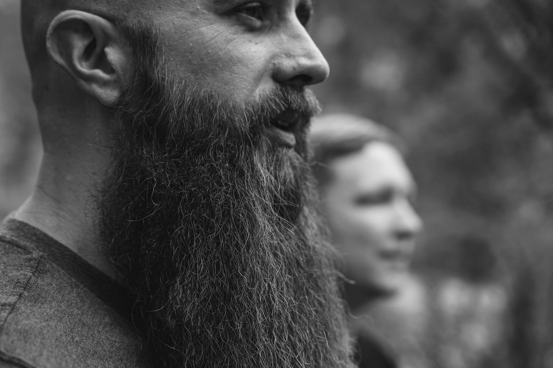 A bald man with a long, full beard in profile