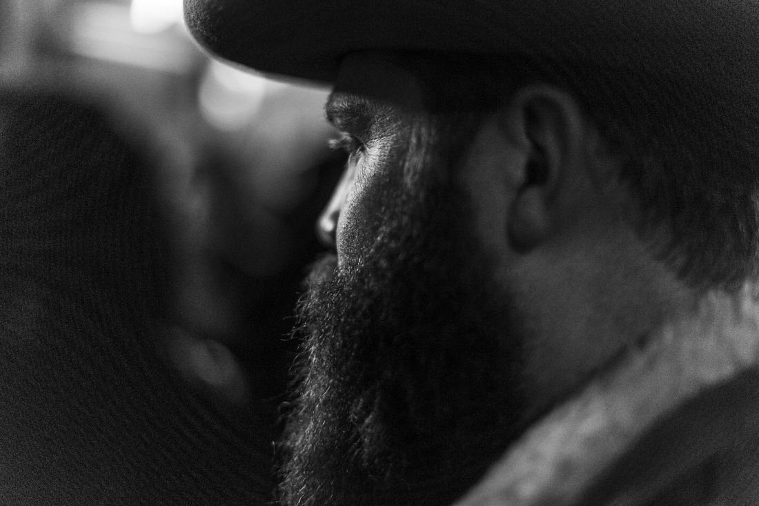 A bearded man in a hat seen in profile