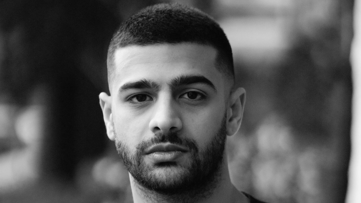A man with a short crew cut and a neat beard