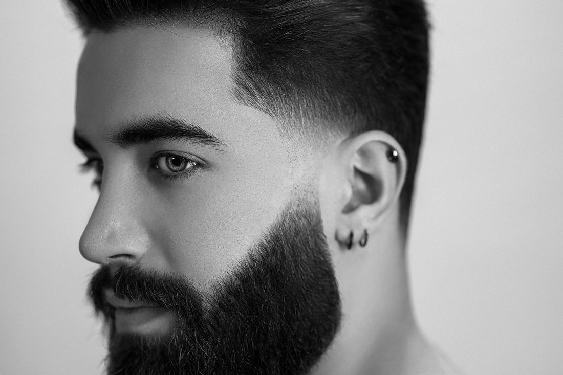 Profile of a man with a full beard and a crisp fade