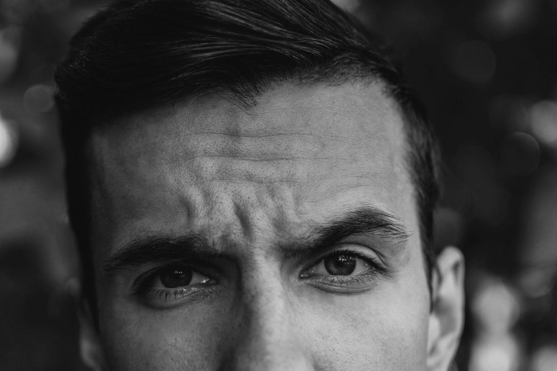 Close-up of a man with short dark hair and an intense expression