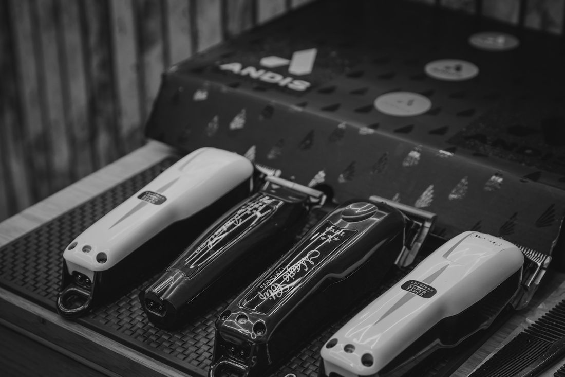Four hair clippers lined up on a black mat
