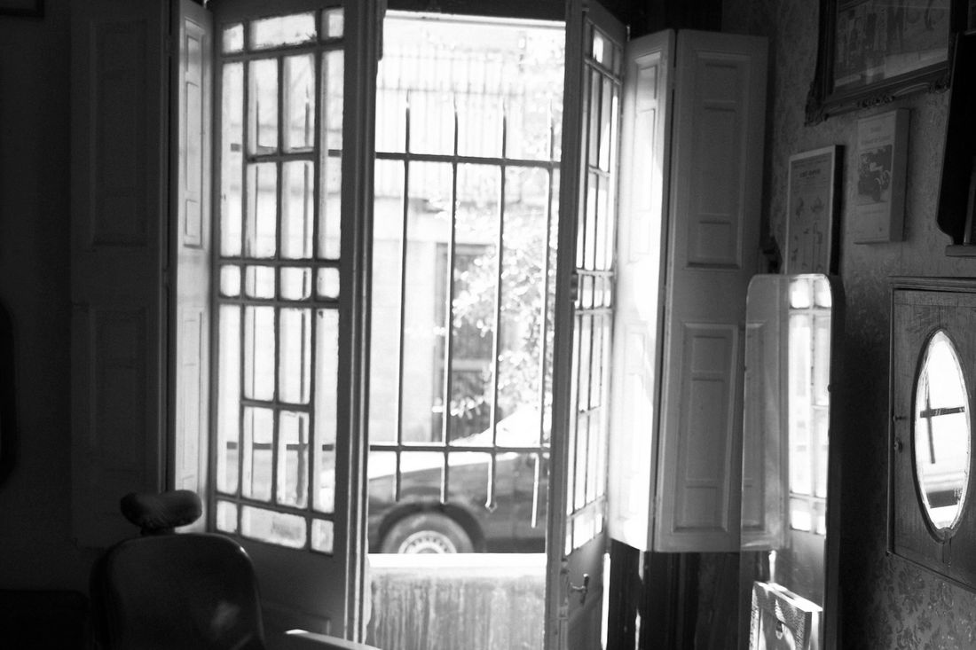 A vintage barber chair in a sunlit doorway