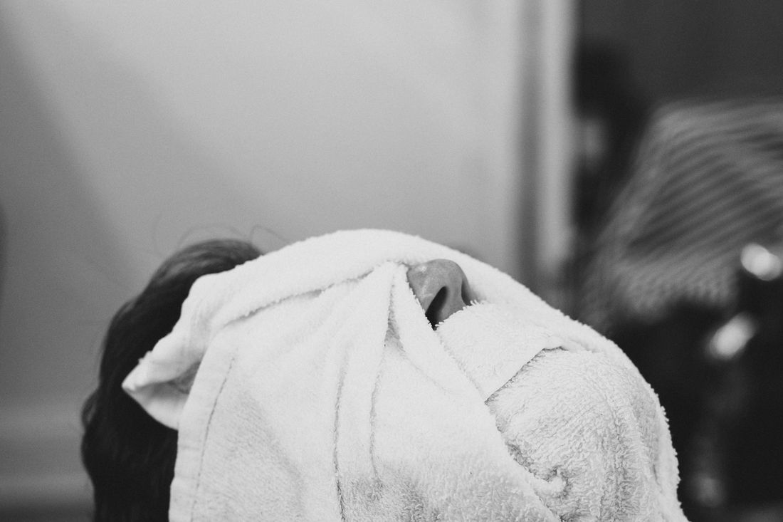 A client lying back with a white towel wrapped around his face
