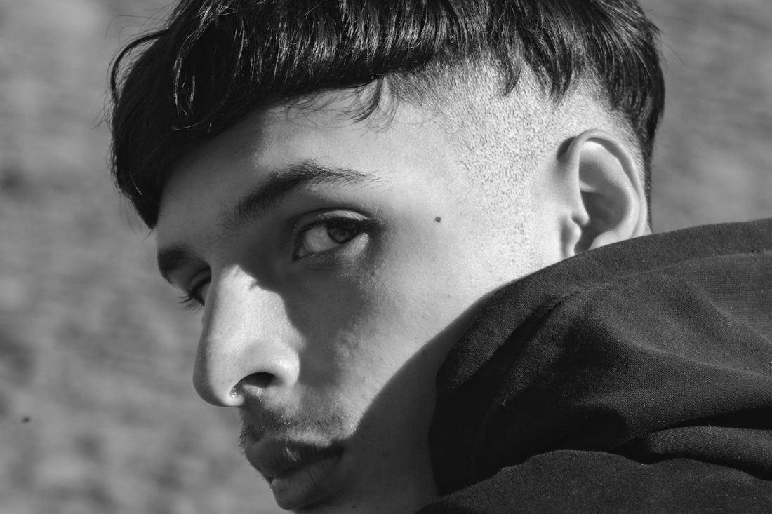 A young man with short textured bangs and neatly tapered sides