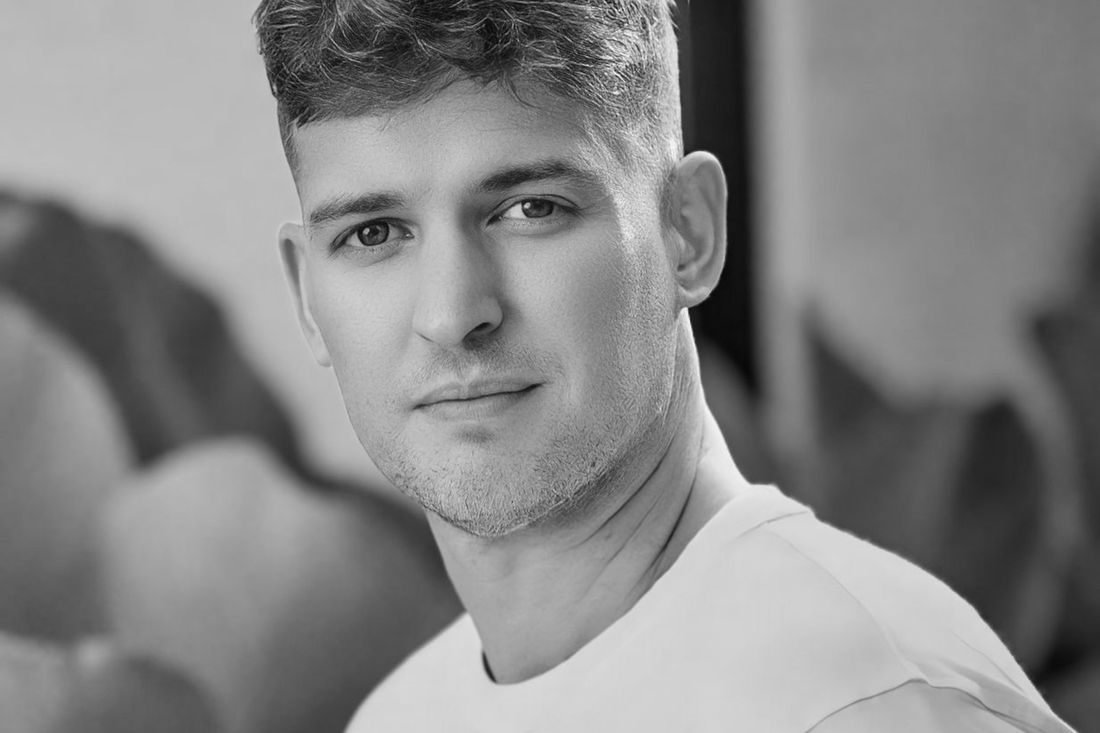 A young man with a short tapered haircut looking at the camera