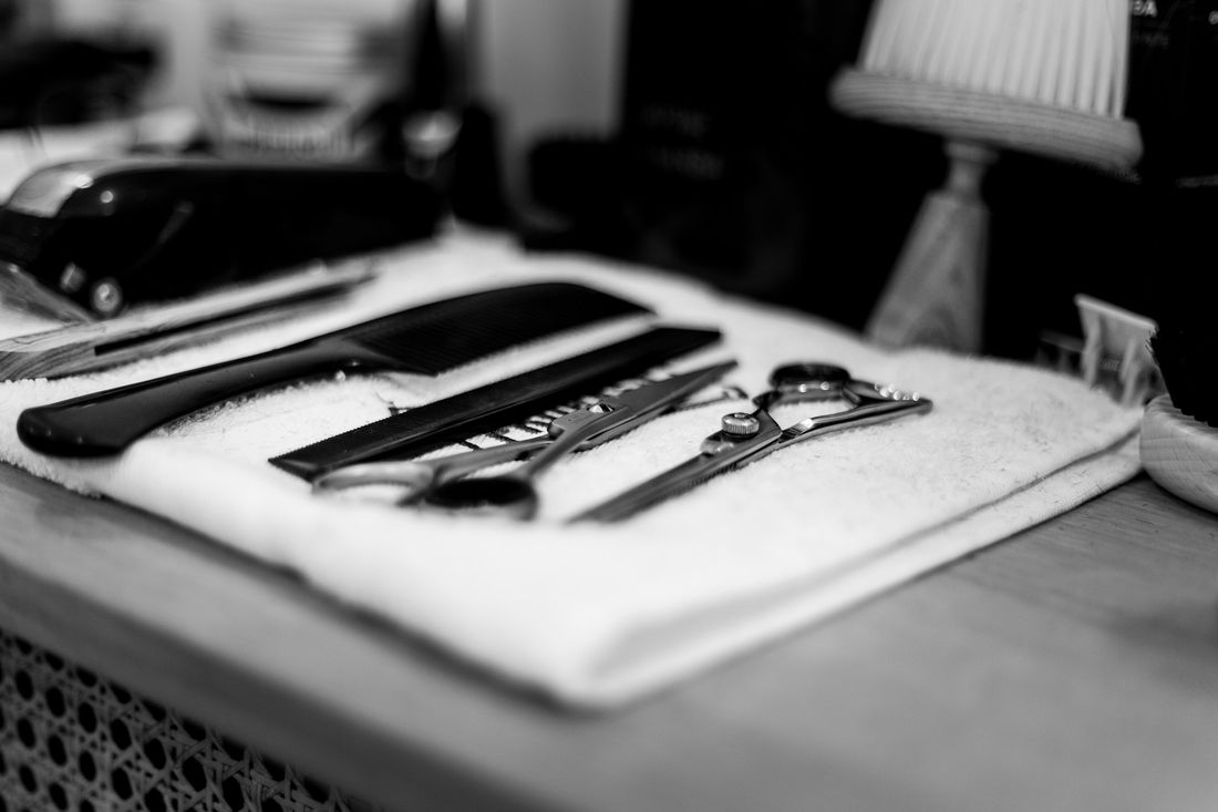 Barber scissors and trimmers laid out on a white towel