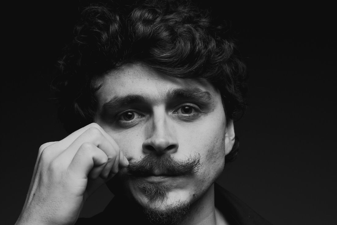 A man twisting the end of his mustache with his fingers