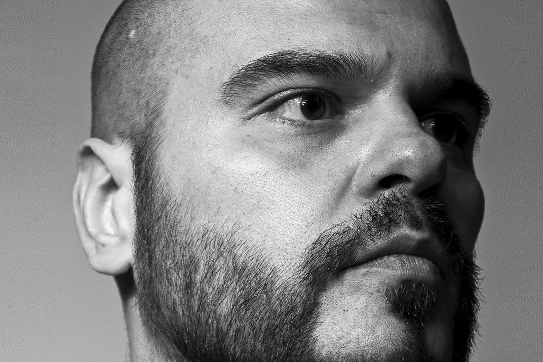 A bald man with a full beard looking to the side