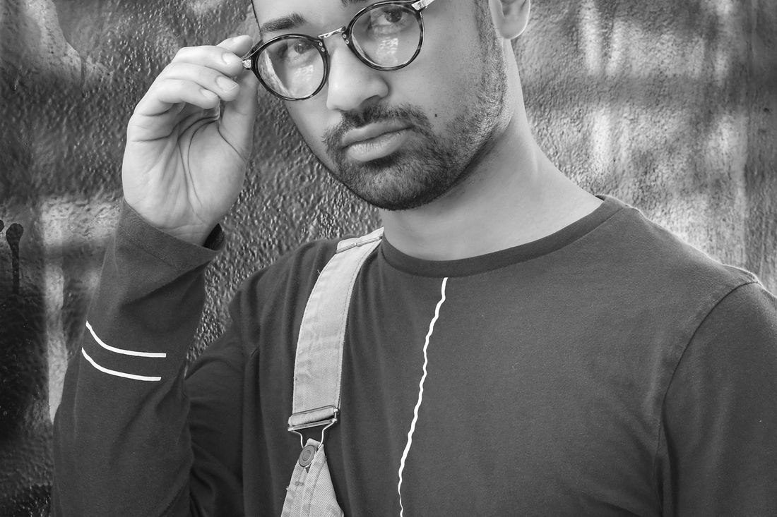 A man in glasses adjusting the frames with one hand