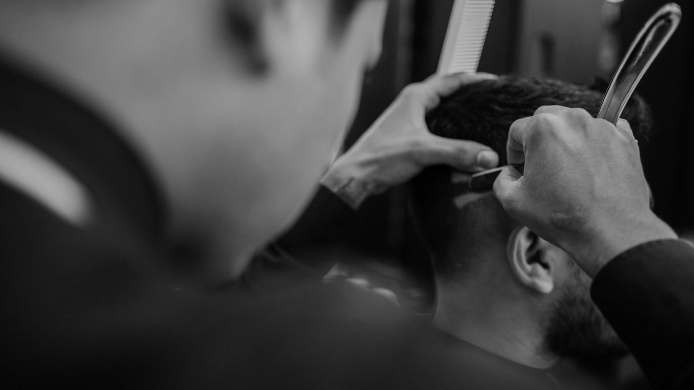 Close-up of a barber's hands cutting a client's hair