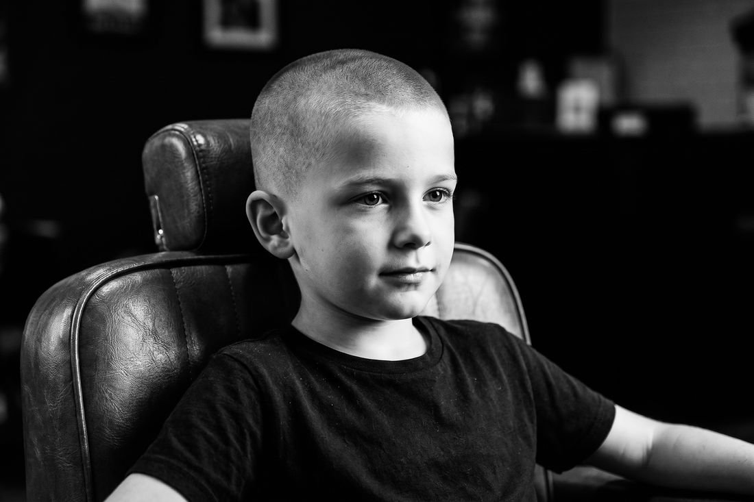 A boy with a buzz cut, one short length all over
