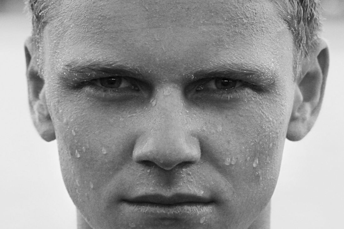 A man with short hair and water droplets on his face