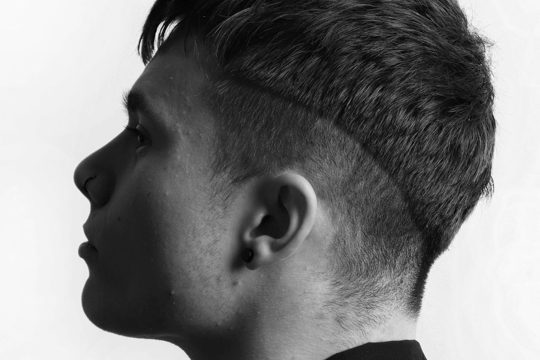 Profile of a young man with short, neatly styled hair