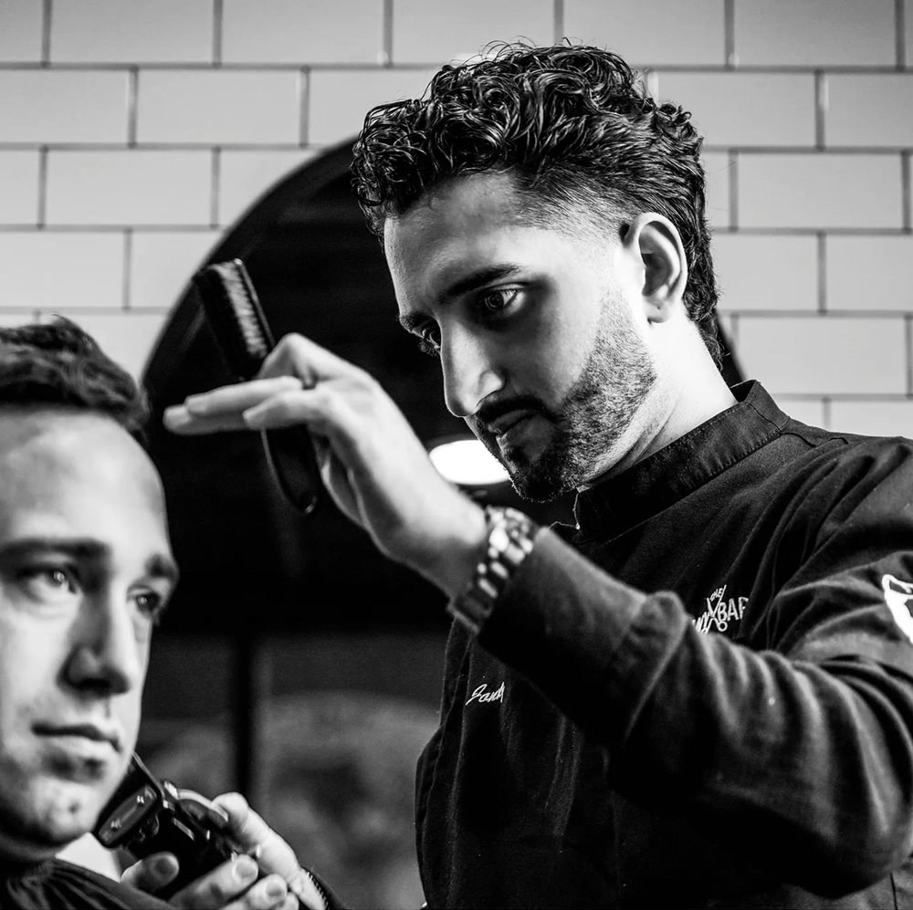 Jonny the Barber cutting a client's hair in the Buffalo shop